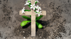 Aschenkreuz und blühende Blume als Symbole des Todes und des Lebens